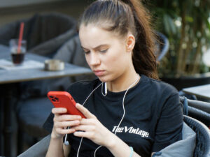 Eine junge Frau schaut auf ihr Handy.